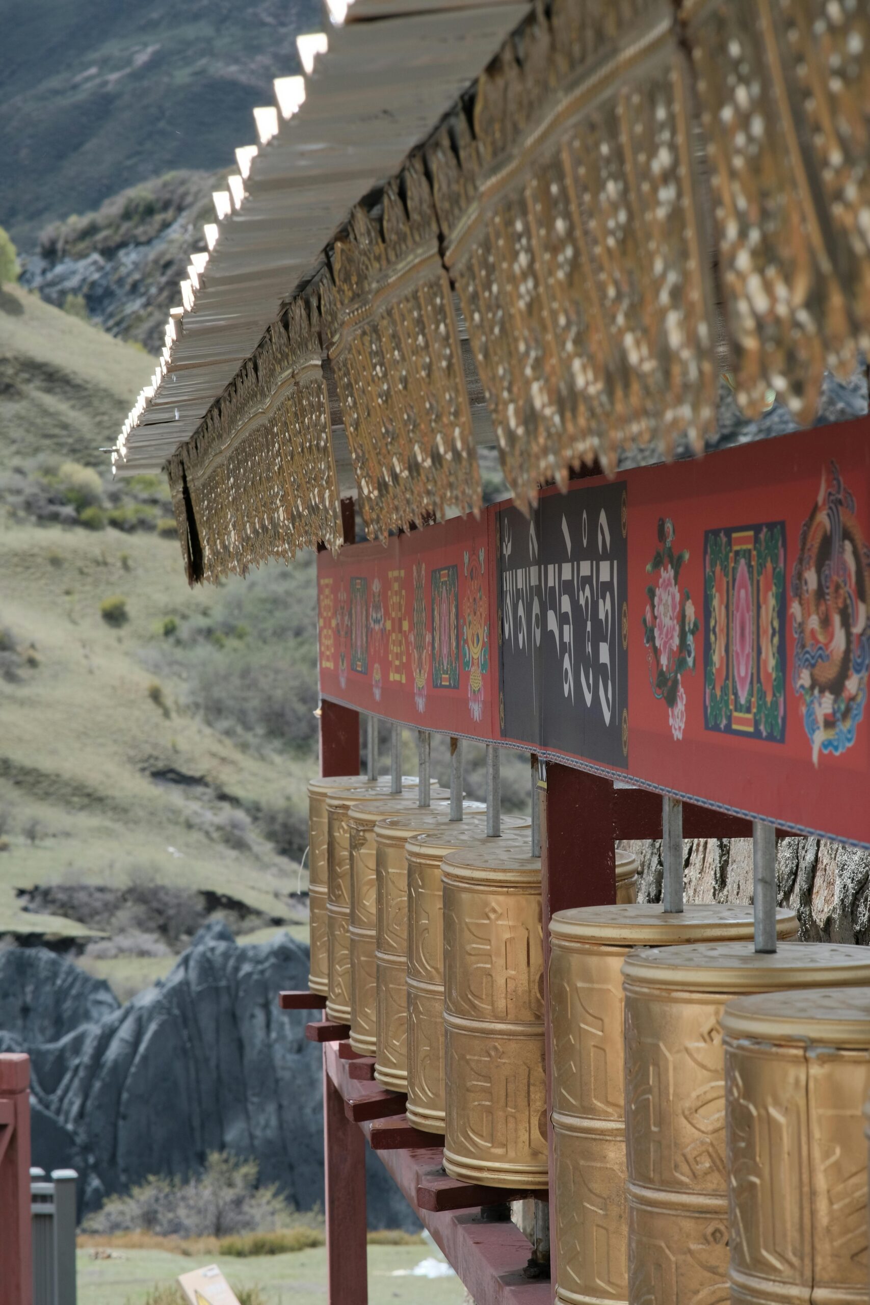 Golden prayer wheels in a Buddhist temple, showcasing spiritual and cultural essence.